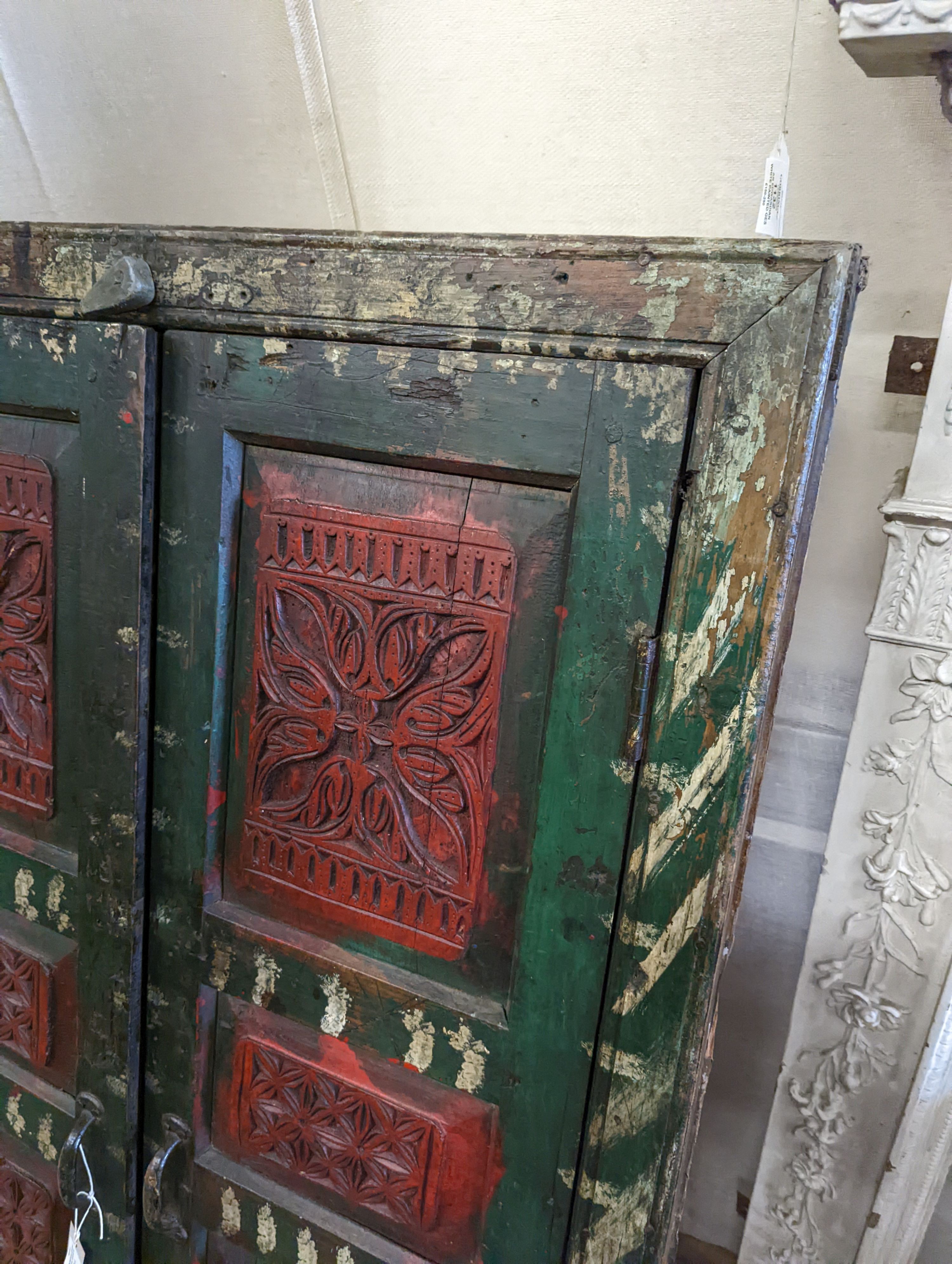 An Indian painted carved hardwood corner cupboard, width 90cm, height 131cm